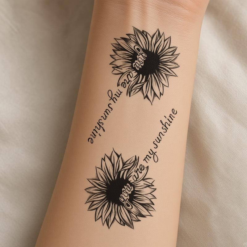 Two black sunflowers with you are my sunshine script temporary tattoo worn on the inner forearm